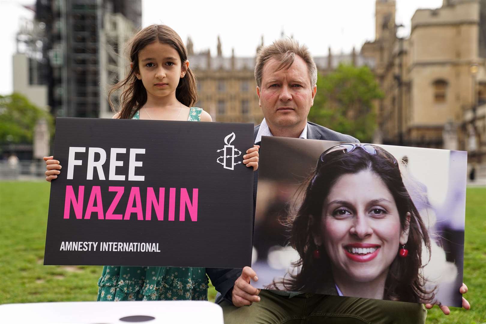 Richard Ratcliffe and his daughter Gabriella hold signs in Parliament Square, London (Kirsty O’Connor/PA)