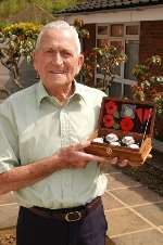 Veteran Len Martin with poppies and sand from the Normandy beaches