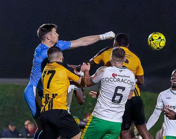 Dover captain and keeper Mitch Walker punches clear in a crowded penalty area. Picture: Helen Cooper