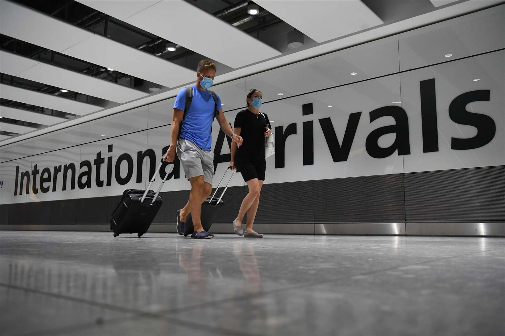 Passengers wearing face masks arrive at Heathrow Airport (Kirsty O’Connor/PA)