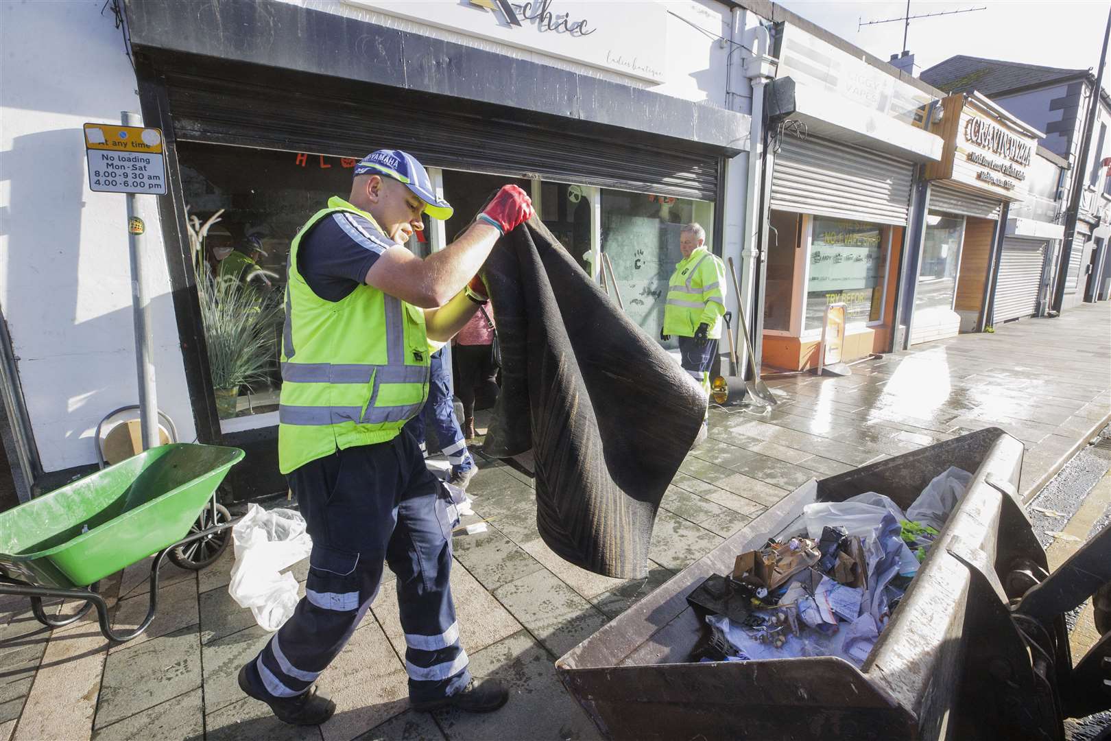 Council workers from Newry, Mourne and Down District Council help clean up flood-stricken Downpatrick, Co Down, where several town centre shops were hit (Liam McBurney/PA)