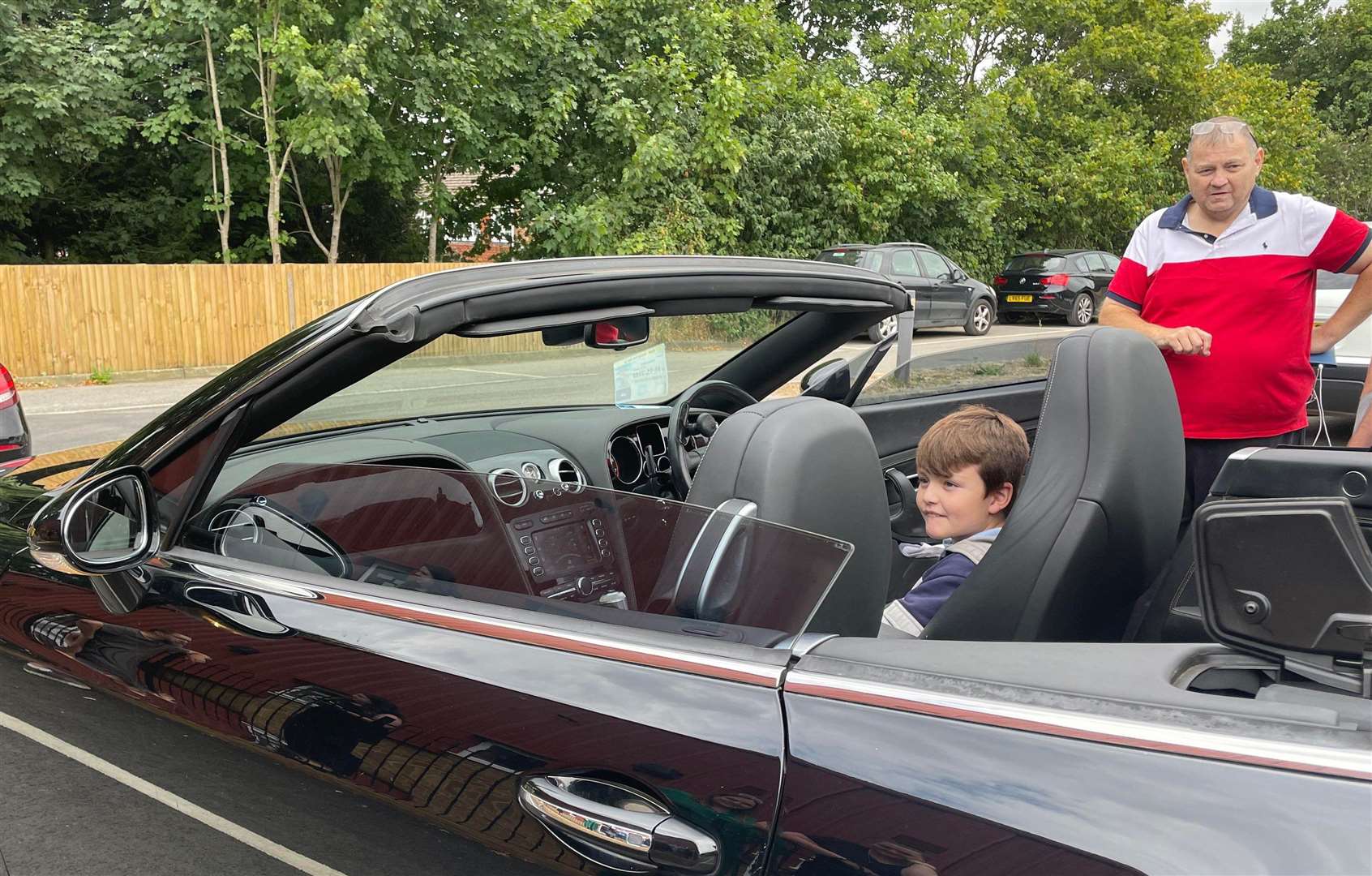 Kevin, in red, showed the children how his adapted convertible Bentley works. Picture: Di Gaffney