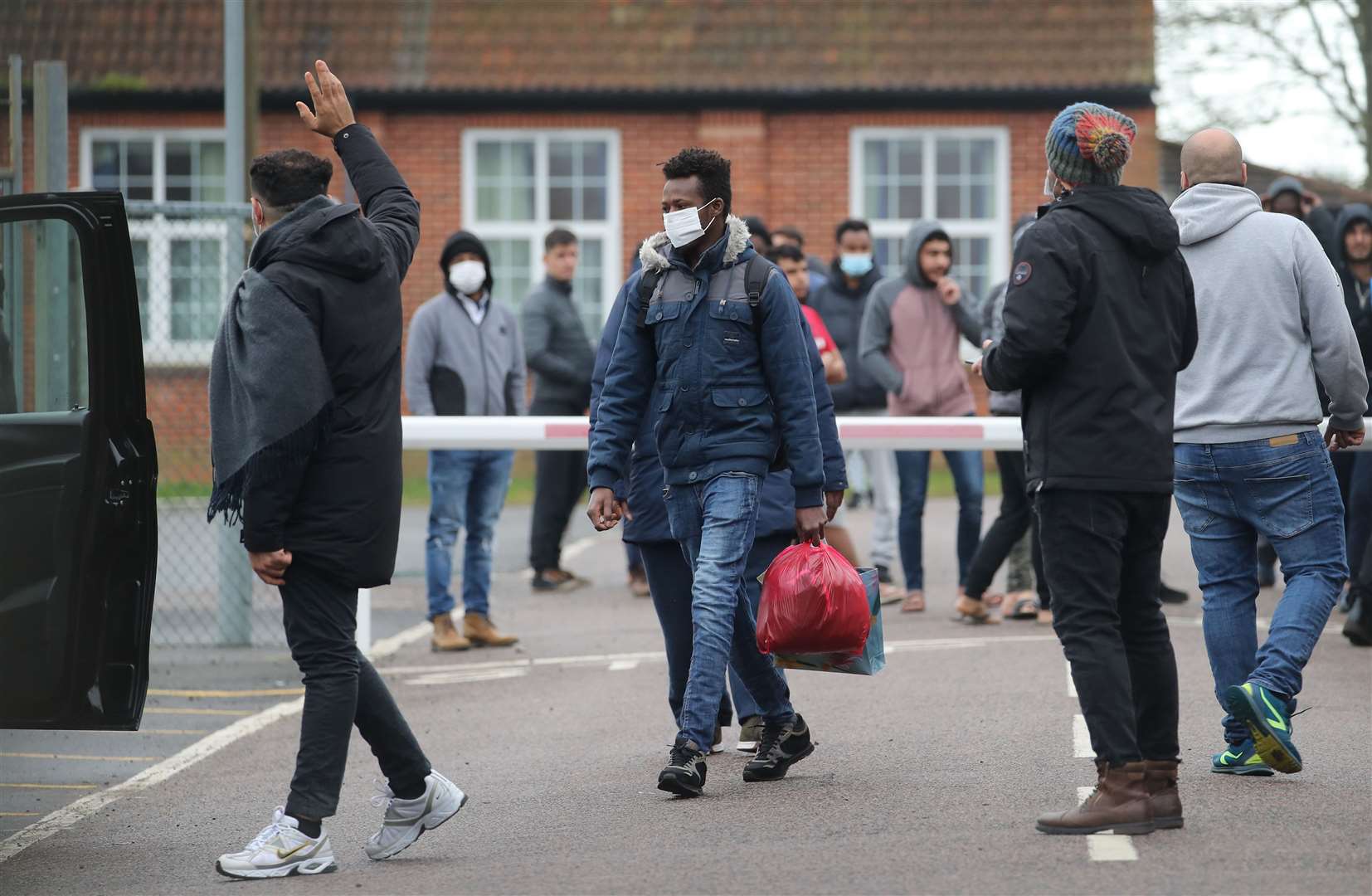 A man carries his belongings as he leaves Napier Barracks in Folkestone, Kent (Gareth Fuller/PA)