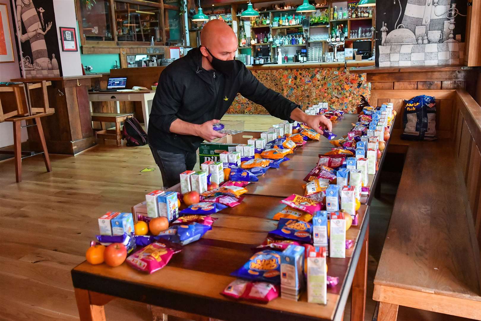 James Koch prepares free packed lunch bags for delivery at the Gallimaufry pub in Bristol (Ben Birchall/PA)