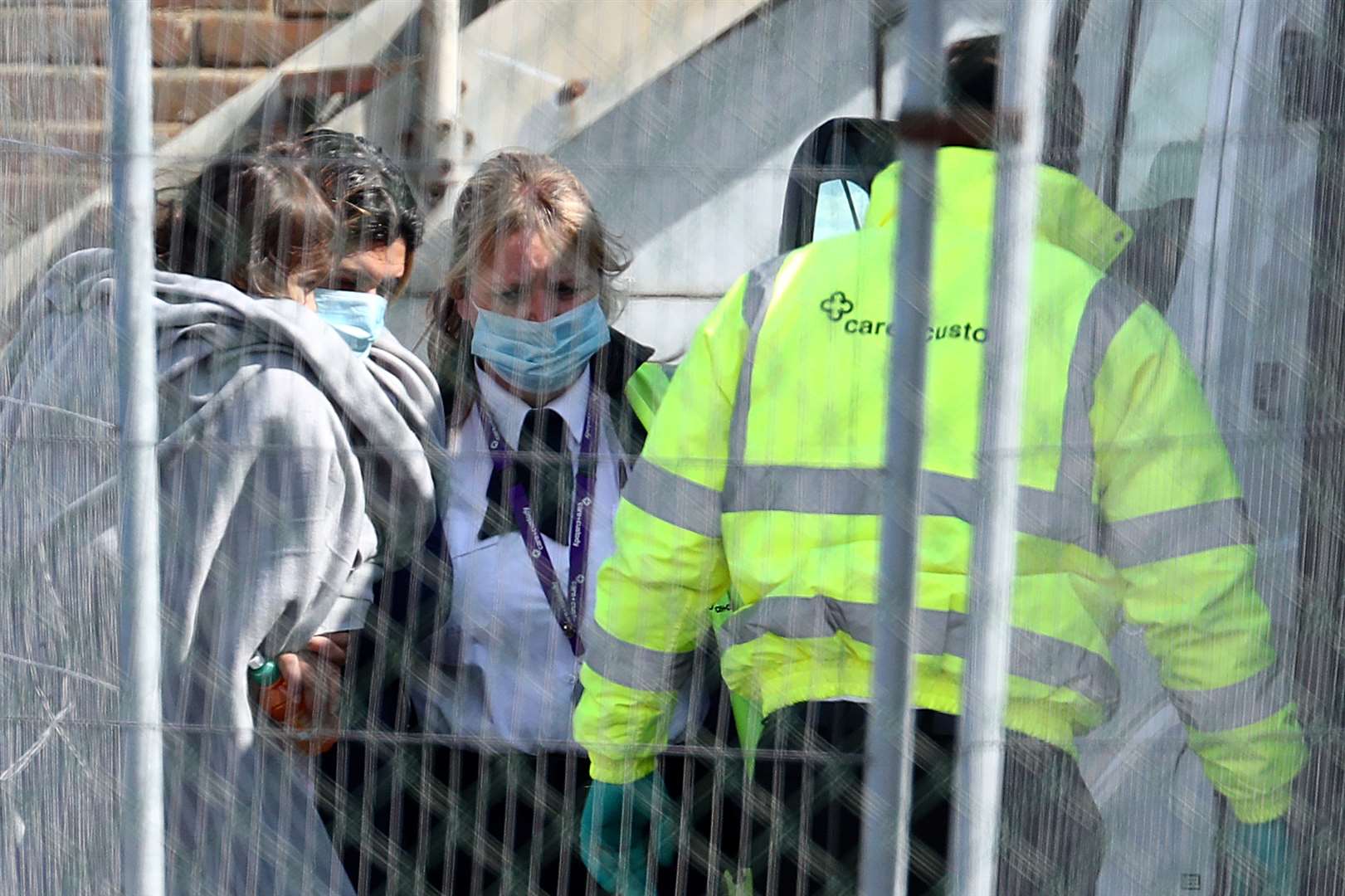 A woman and child, thought to be migrants, are escorted to a van by Border Force officials (Gareth Fuller/PA)