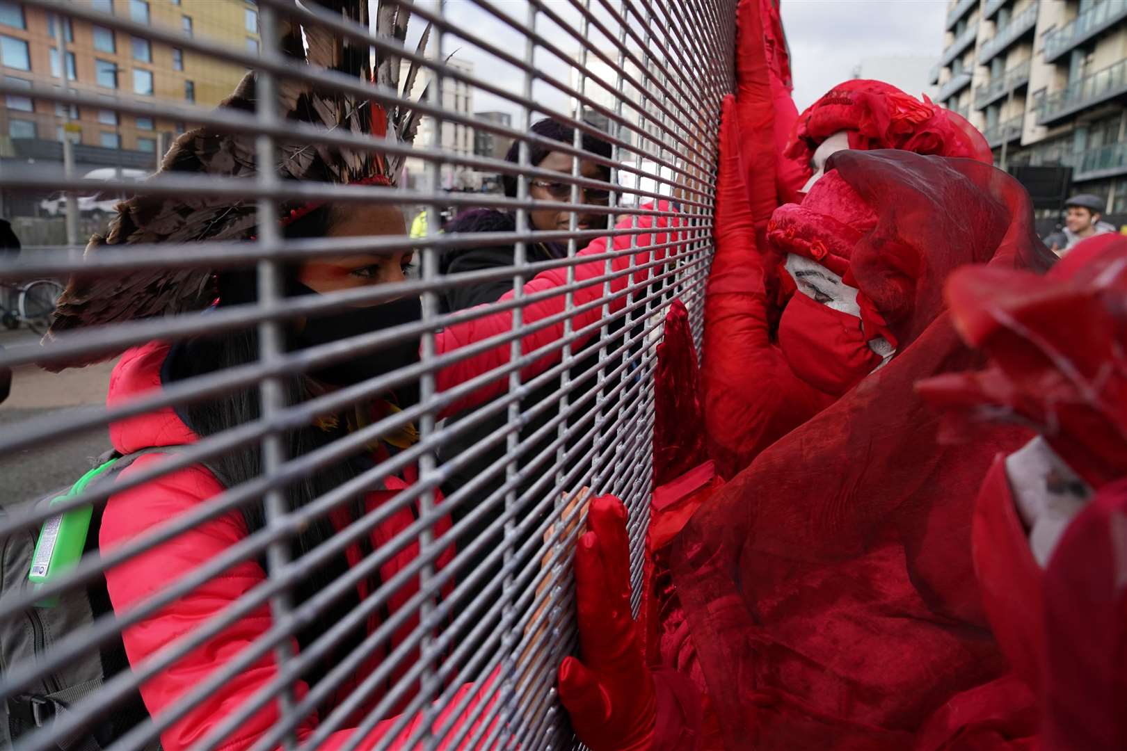 Members of the Red Rebel Brigade outside the Scottish Events Campus speak to delegates inside through the fencing on the perimeter (Andrew Milligan/PA)