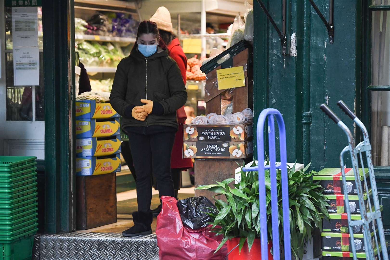 A shop worker wearing a face mask in China Town, Leicester Square (PA)