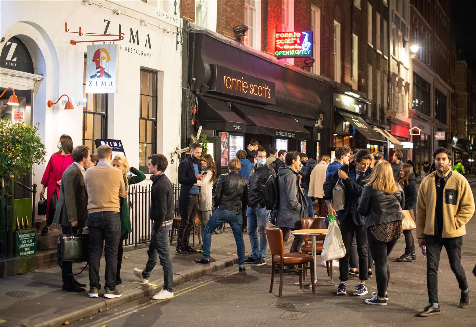 People leave bars and restaurants at closing time in Soho the day after pubs and restaurants were subject to a 10pm curfew (Dominic Lipinski/PA)