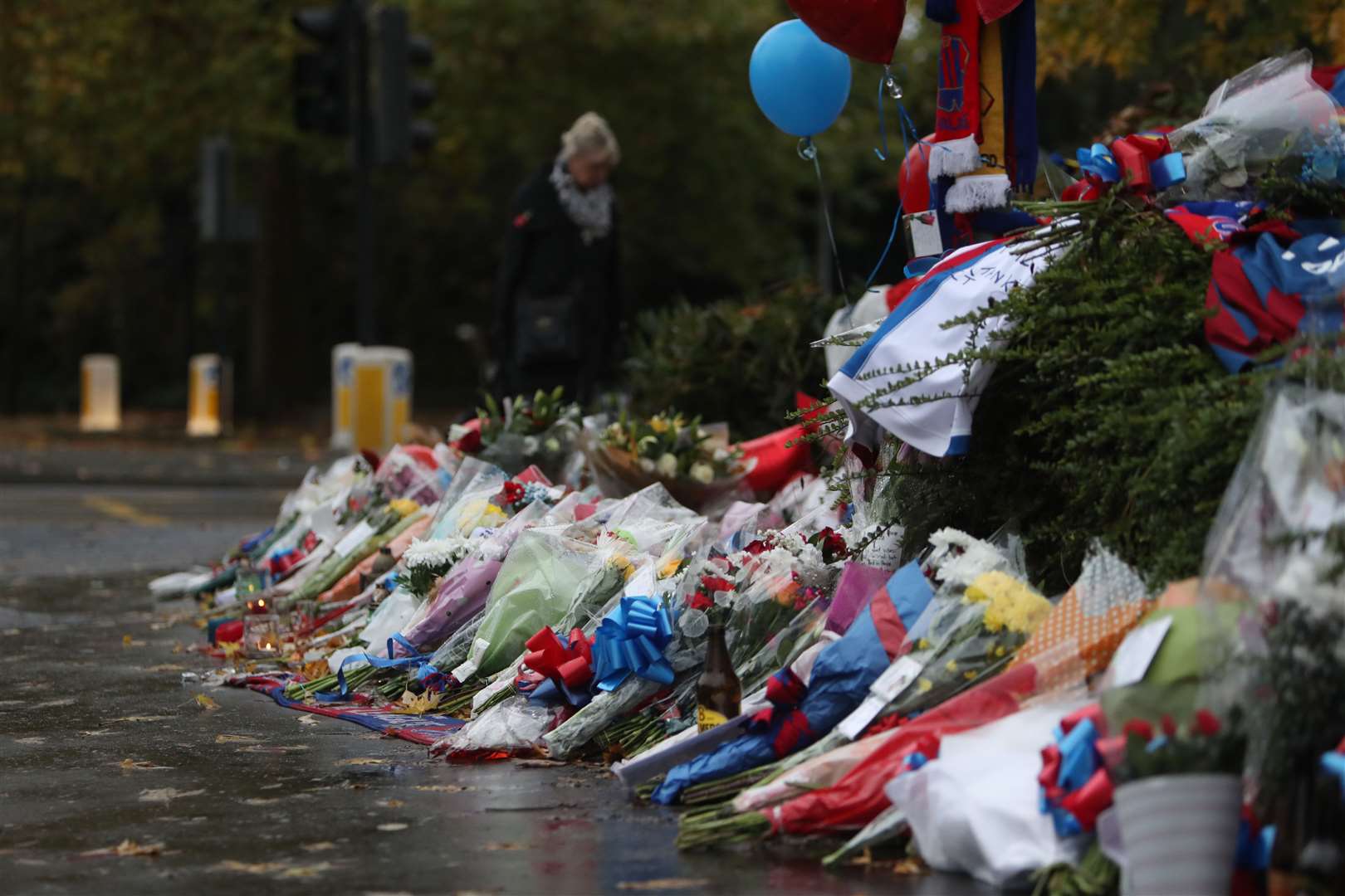 People look at floral tributes left near the scene where the tram crashed (Steve Parsons/PA)