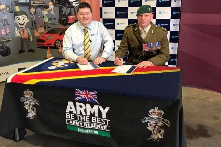 Managing director Mark Smith, left, signs the military covenant with Commanding Officer Lt Col John Hanson MBE