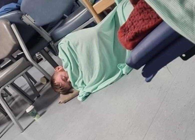 Steven Wells sleeping on the floor in A&E during his long wait at the William Harvey Hospital in Ashford