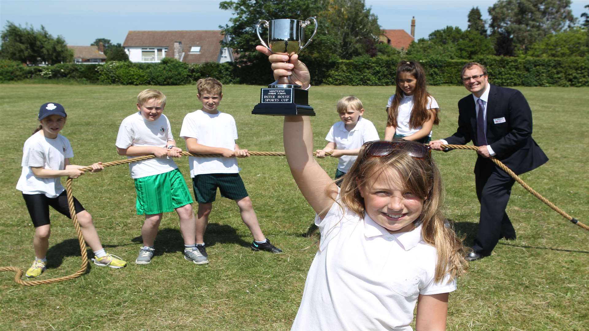Florence, 11, holds up a trophy that her Year 6 team won in a tug-of-war competition