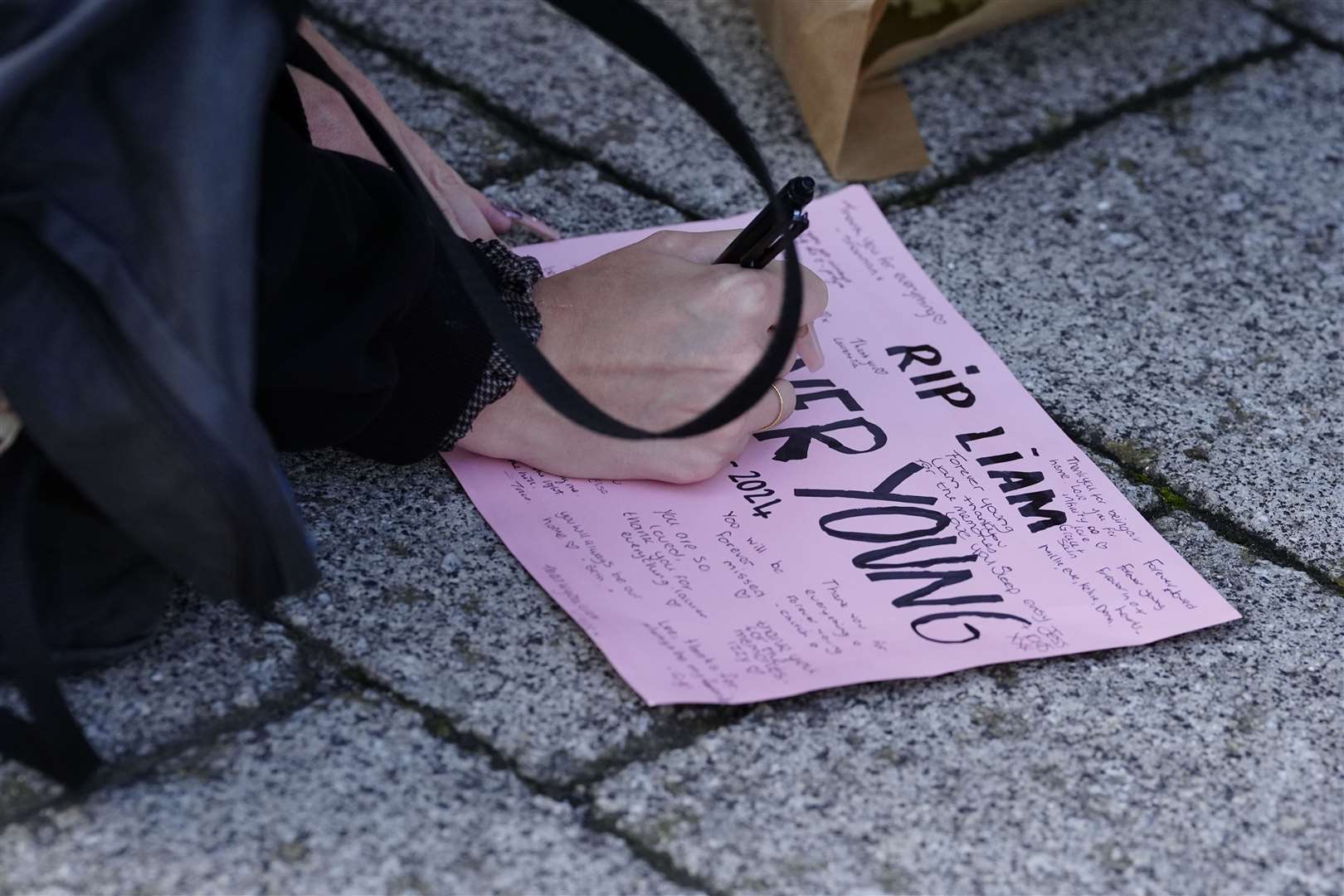 A fan writes a tribute message (Peter Byrne/PA)