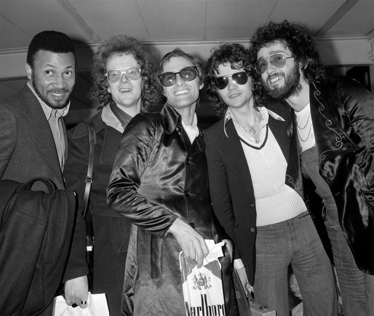 Steve Harley (centre) and Cockney Rebel, currently top of the best selling pop charts with Make Me Smile, at London’s Heathrow airport on their arrival from the US and two-week tour of one-night stands (PA)