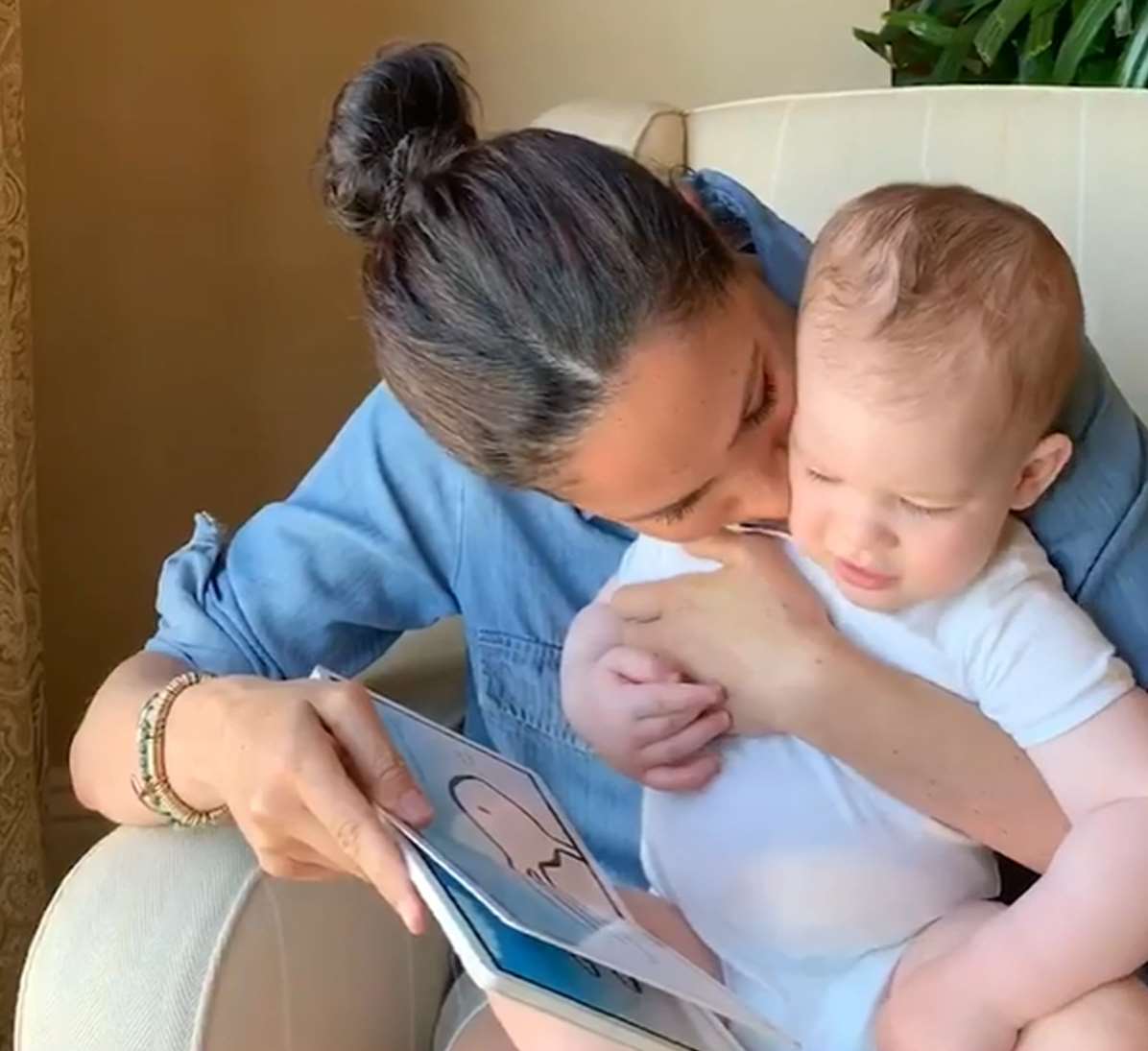 Meghan gives her son a kiss as she reads from the book (Duke of Sussex/PA)