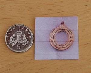 The 1,400 year old gold pendant, seen in an actual size scan, alongside a 5p coin.
