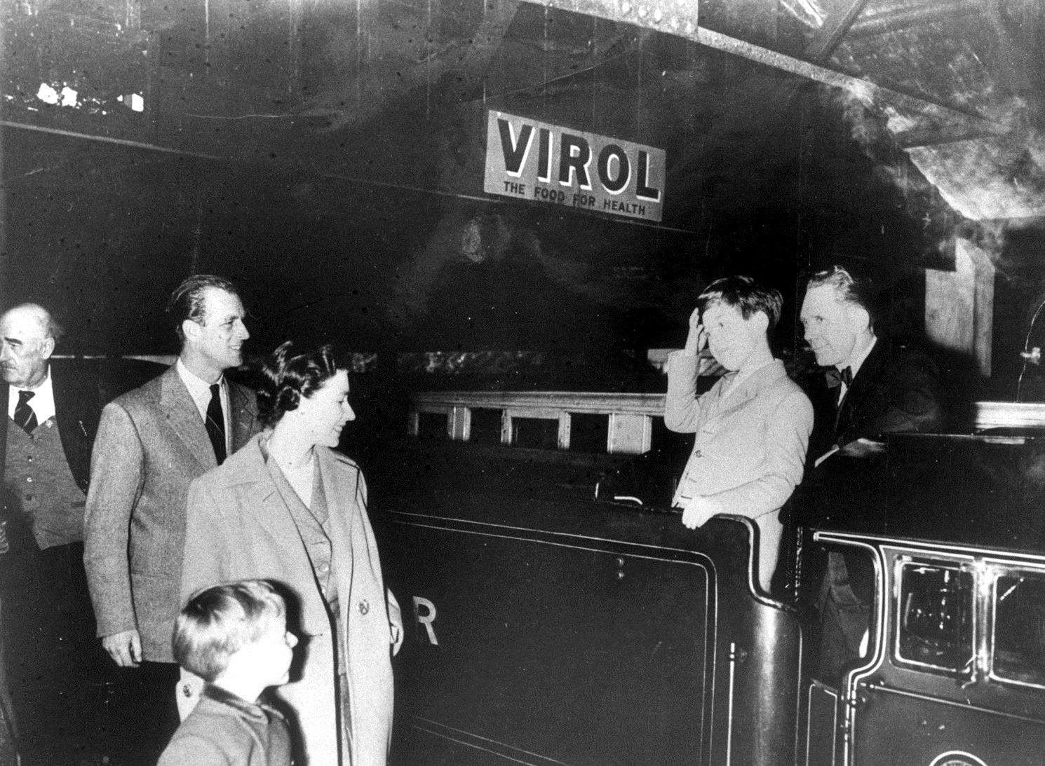 The Queen smiles as Prince Charles joins foreman driver George Balow on the footplate of the Hurricane During a visit to the railway in April 1957