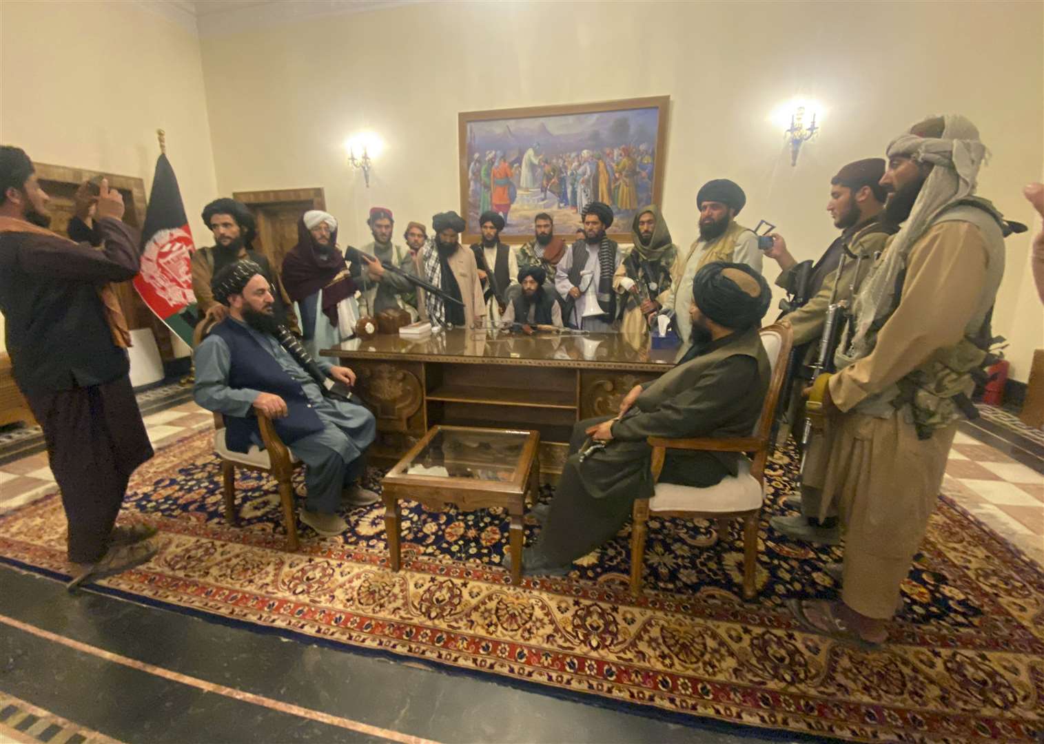 Taliban fighters take control of the Afghan presidential palace in Kabul after President Ashraf Ghani fled the country (Zabi Karimi/AP)