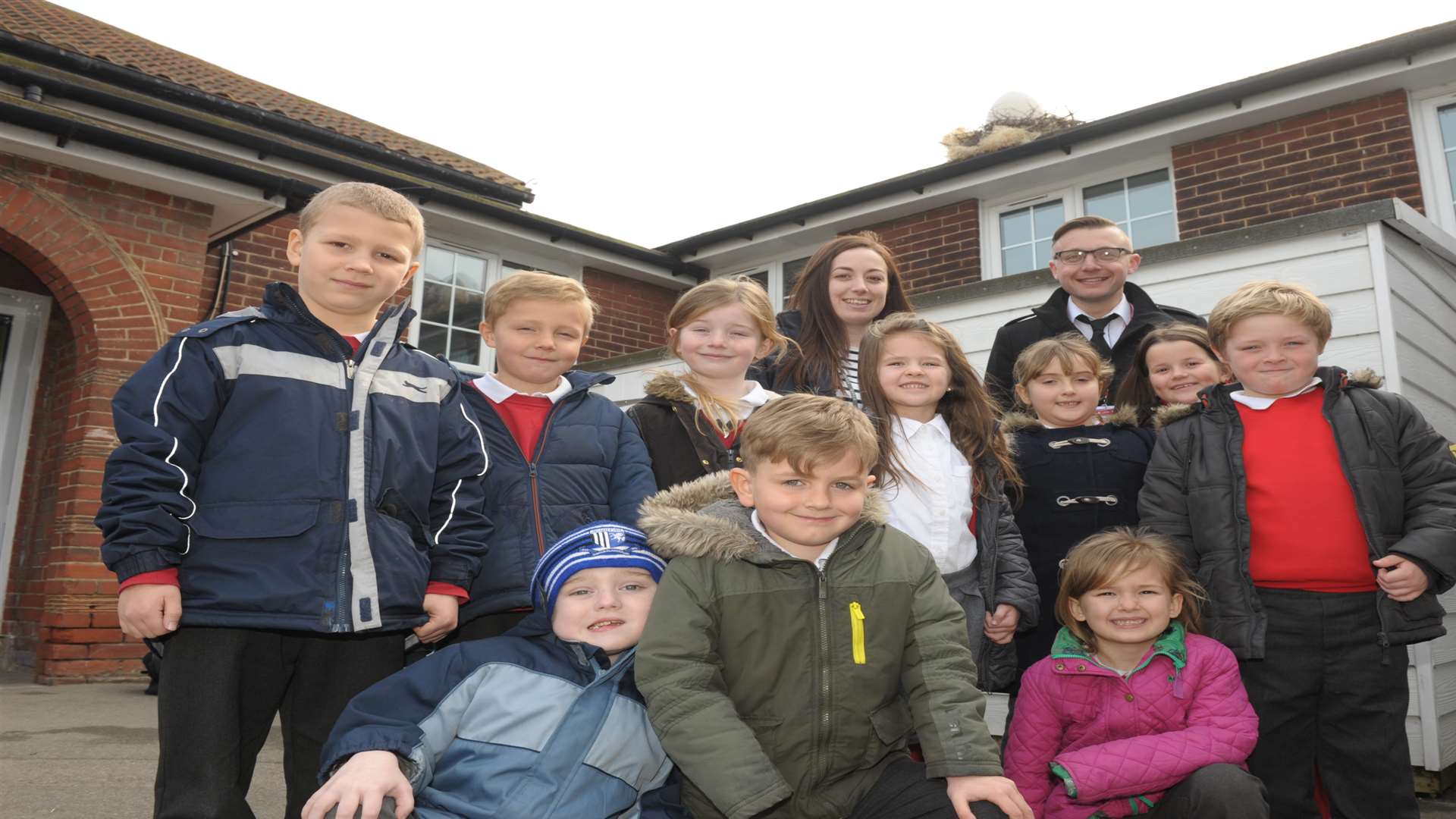 Teacher Christina Stapley and actor Steve Wickenden with children and the mysterious egg on the roof