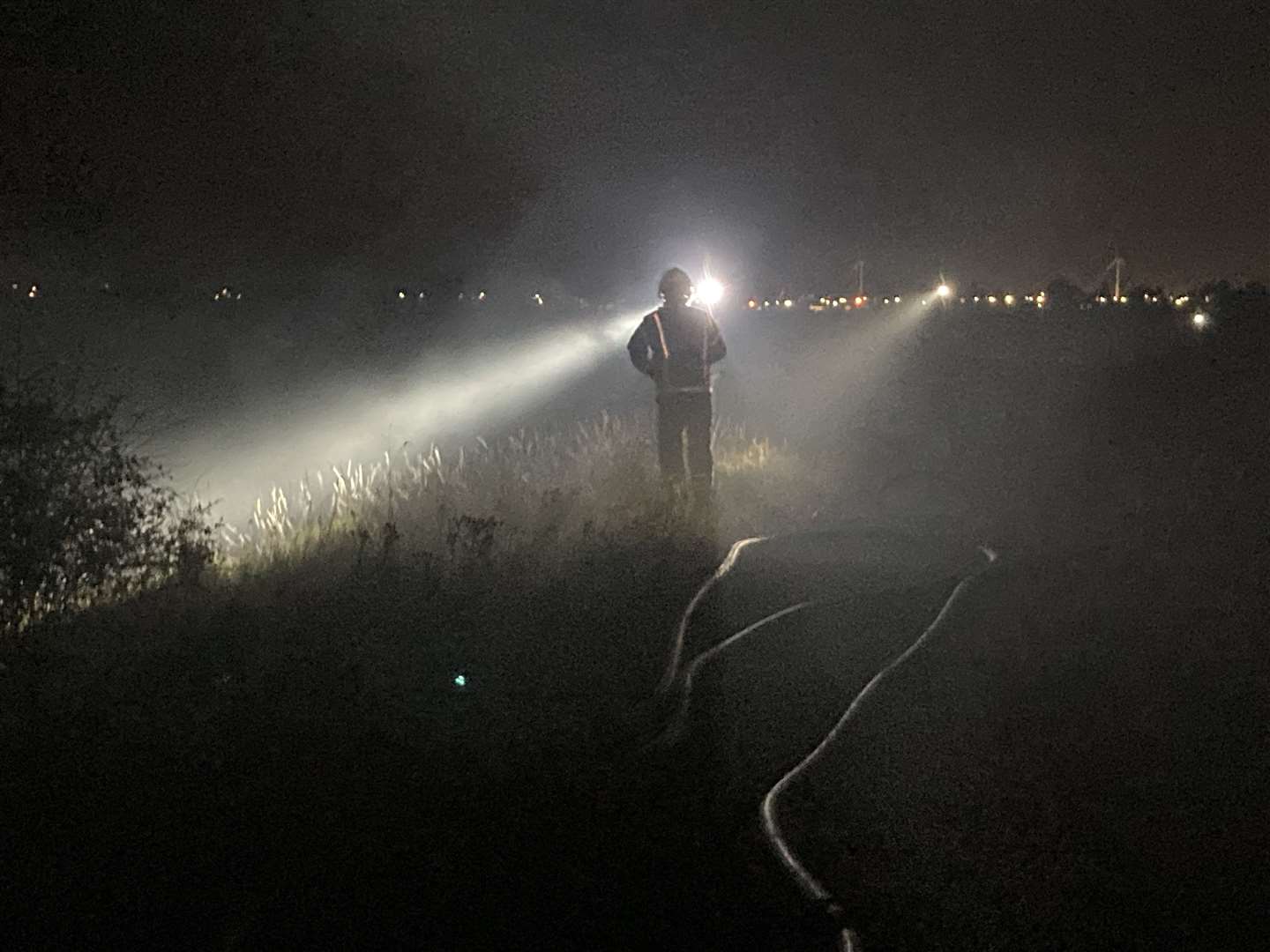 Firefighters tackle burning grass following a model aeroplane display at Barton's Point Coastal Park, Sheerness. Picture: John Nurden