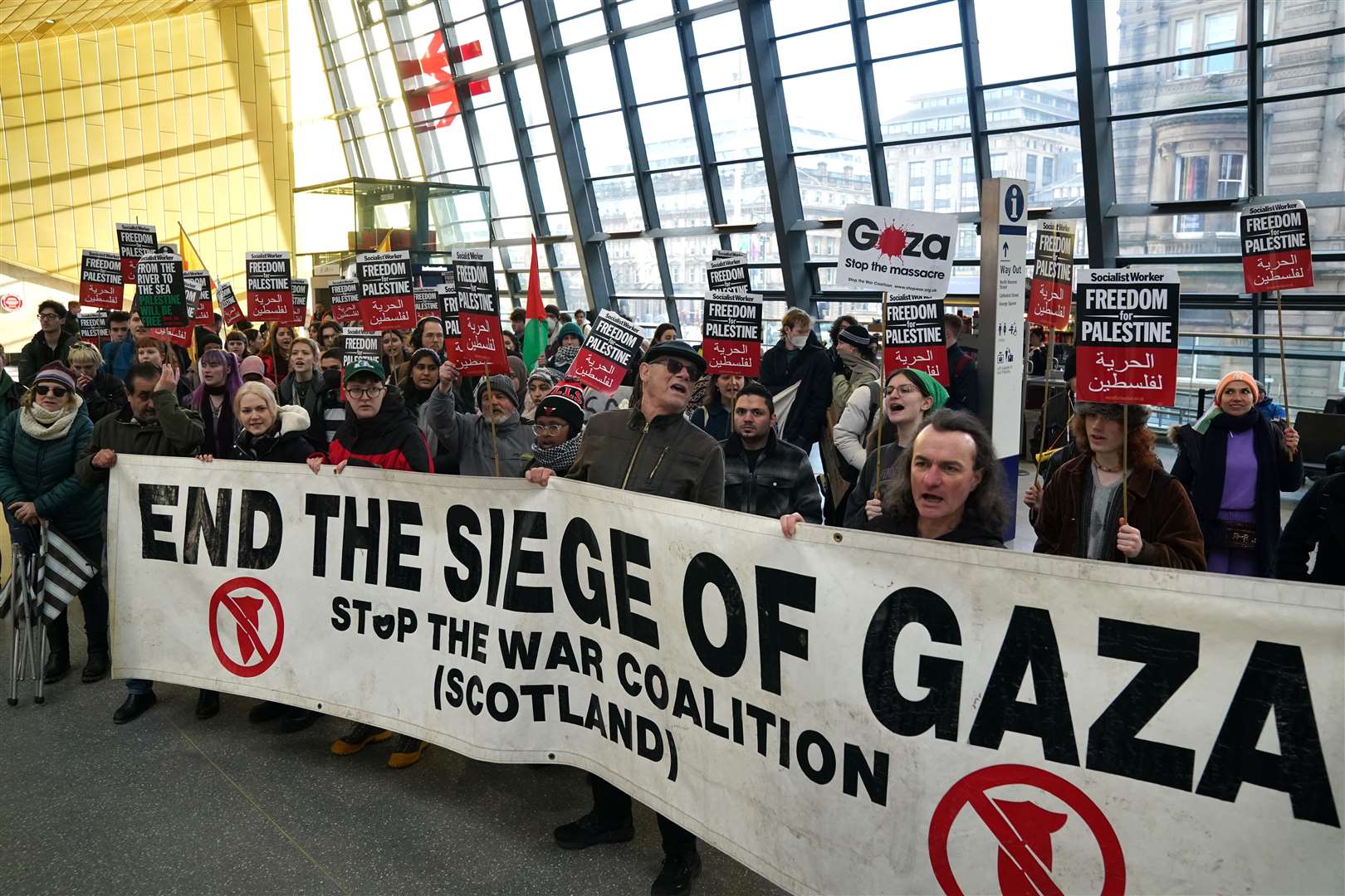 School and university students take part in a sit-down protest in Queen Street Station (Andrew Milligan/PA)