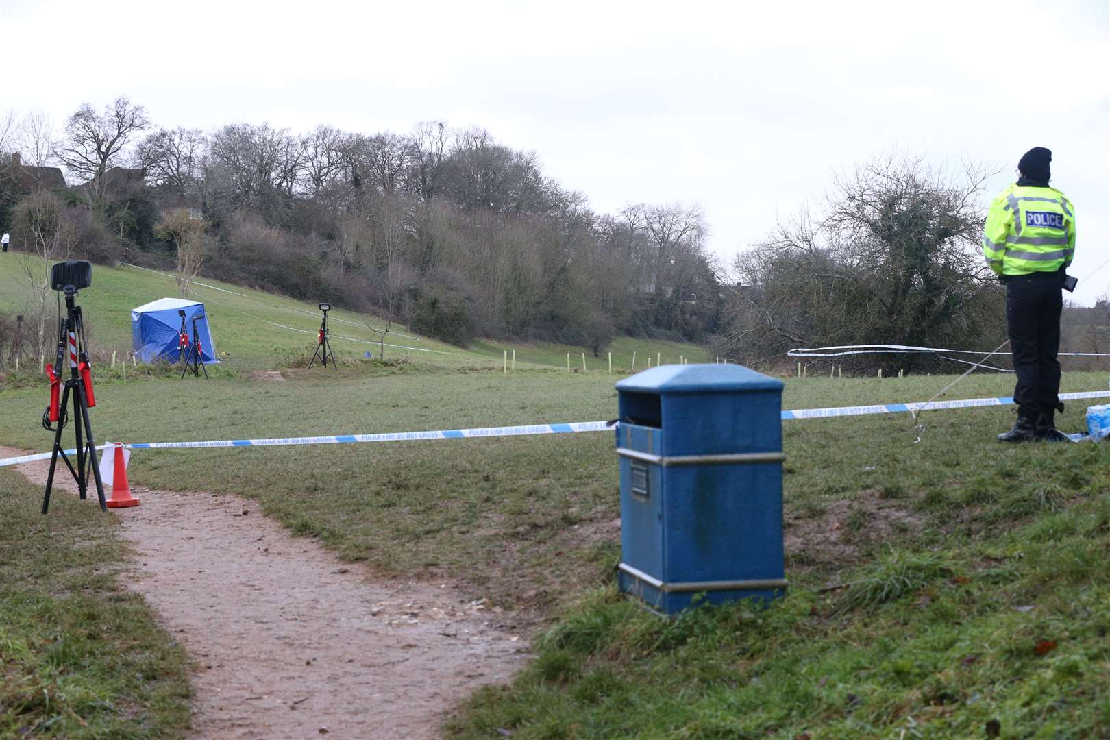 A police officer watches as a forensic tent is set up in Bugs Bottom fields in Emmer Green (Jonathan Brady/PA)