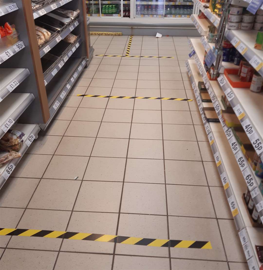 Hazard squares marked out with tape on the floor of Tesco Express (32521927)