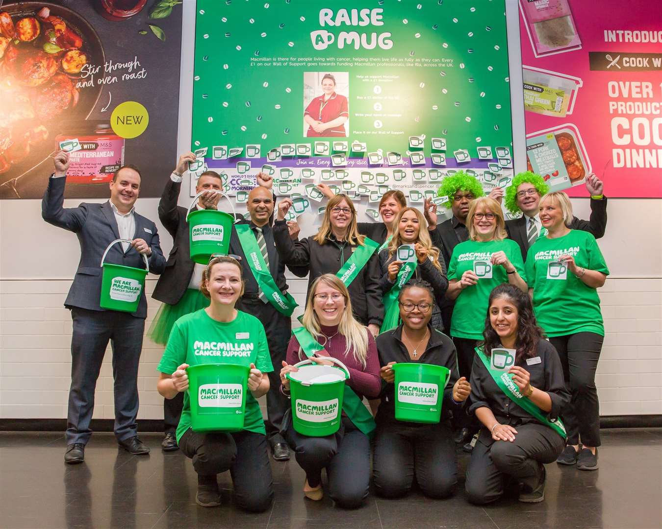 M&S staff gather outside the Bluewater store's 'Wall of Support' in aid of Macmillan's coffee morning taking place on Friday 27 September. (17693693)