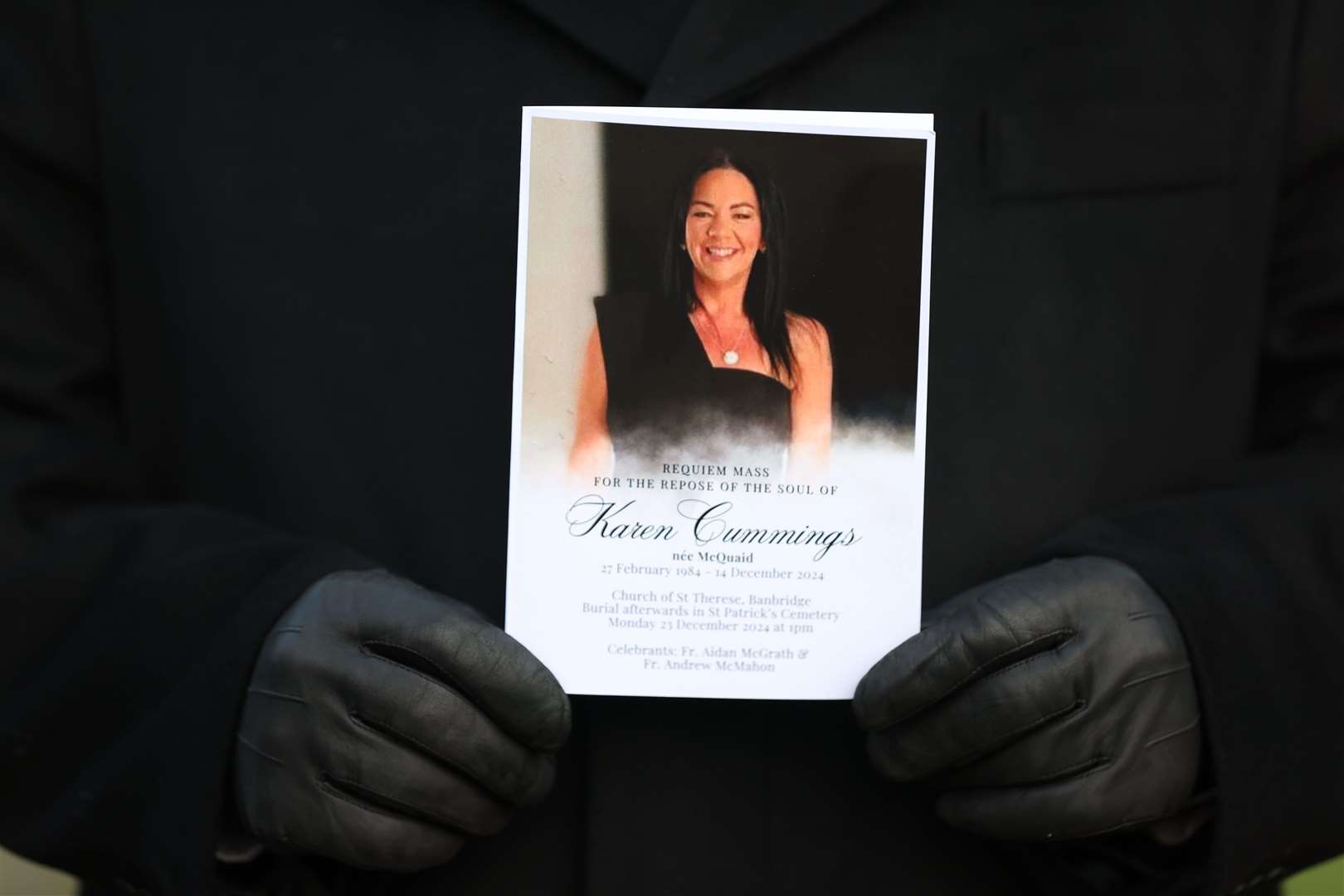 A mourner holds an Order of Service at the funeral of Karen Cummings (Liam McBurney/PA)