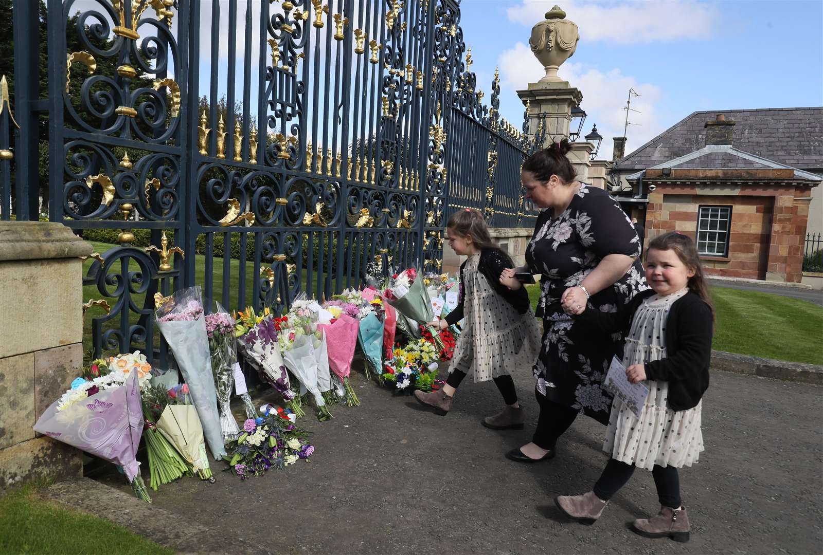 Naomi Armstrong-Cotter and her daughters Lillie, six, (left) and Essie, five, arrive at the gates of Hillsborough Castle in Northern Ireland, to lay flowers (Brian Lawless/PA)