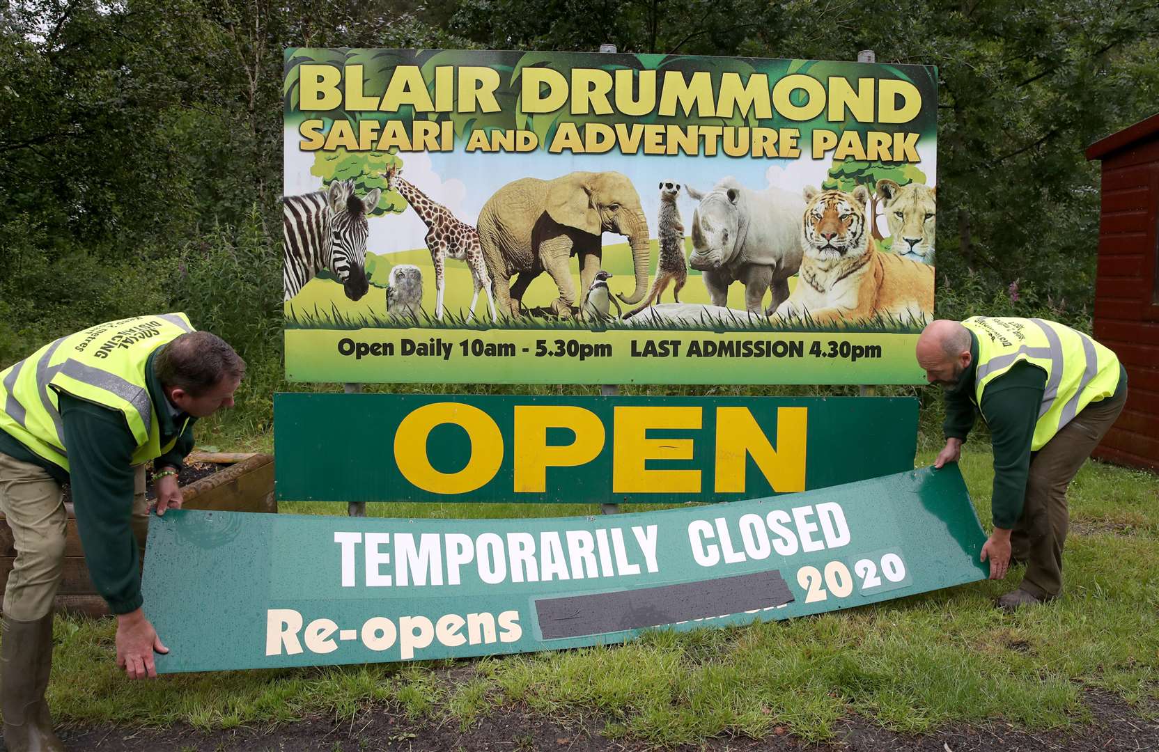 Staff remove the temporary closed signs at the entrance as Blair Drummond Safari Park near Stirling prepared to reopen (Andrew Milligan/PA)