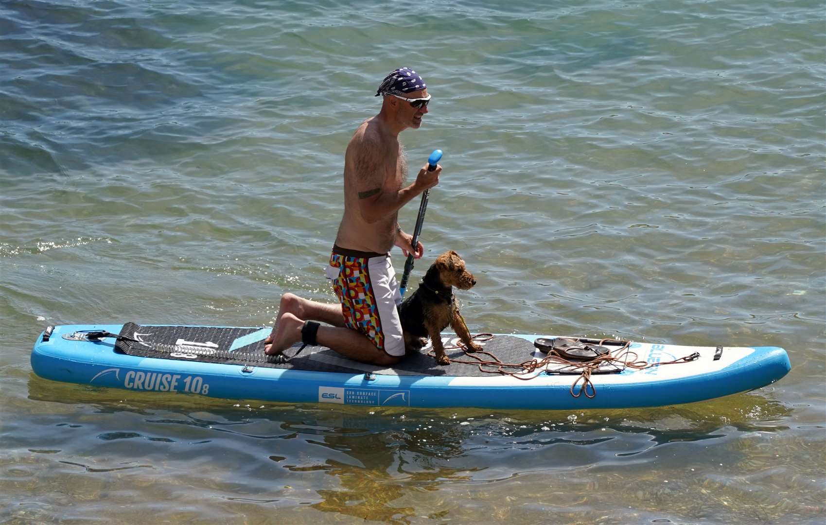 A man paddleboards with his dog (Andrew Matthews/PA)