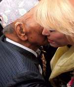 Joanna Lumley catches a whisper from Tul Bahadur Pun VC amid the press throng outside the Royal Courts of Justice