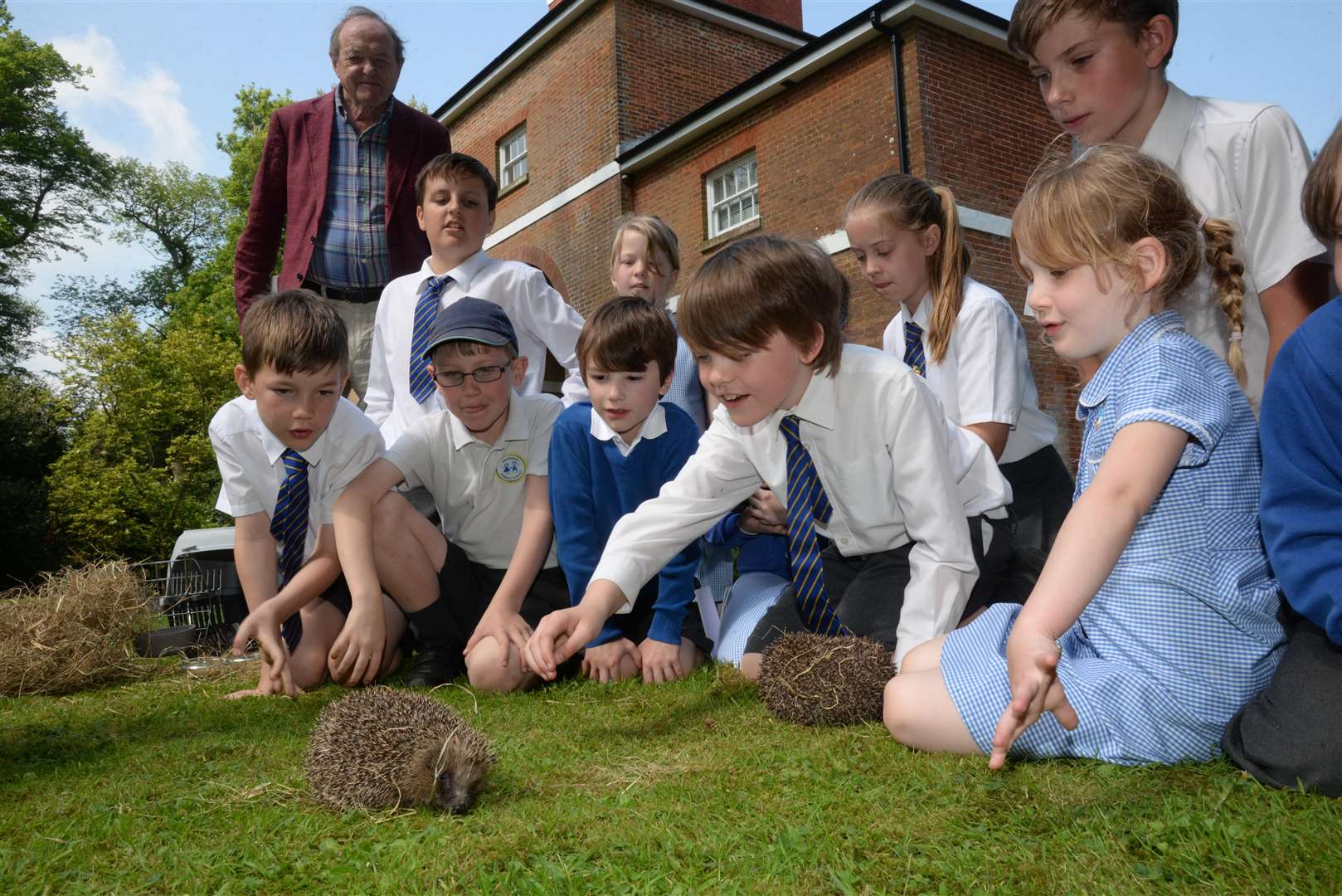 Actor James Bolan watches Frank Tett discussing hedgehog's with children from Sheldwich School at the Lees Court Estate on Tuesday. Picture: Chris Davey (2016412)