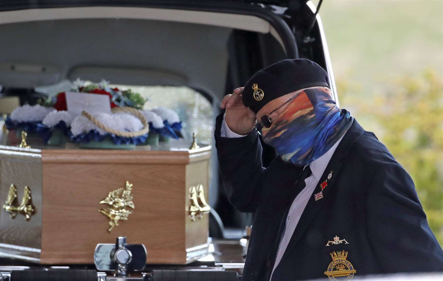 A retired submariner tips his hat as he passes the coffin at Stirling Crematorium (Andrew Milligan/PA)