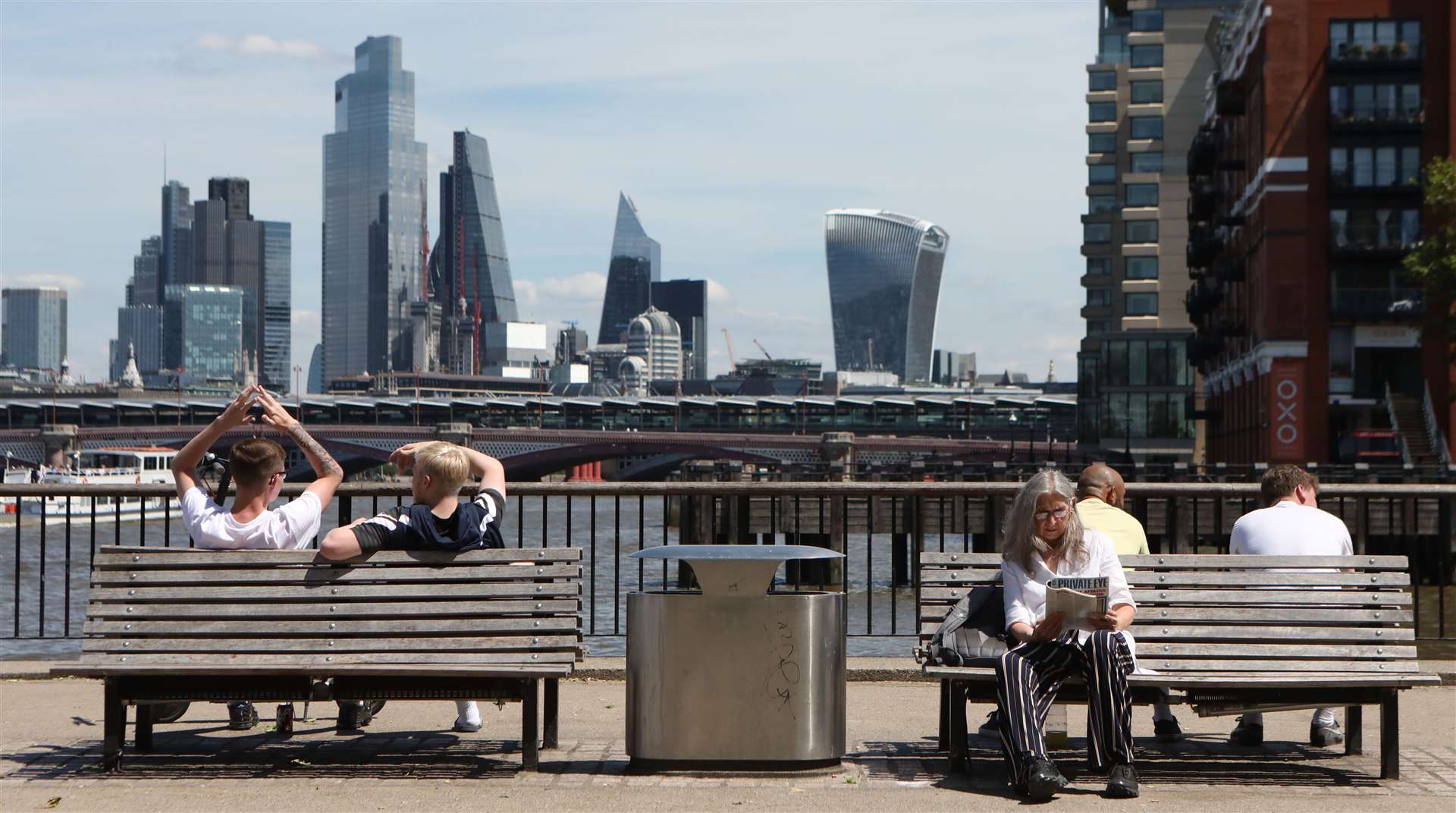 People enjoy the sun and view at the observation point looking over the Thames Beach in central London (Luciana Guerra/PA)