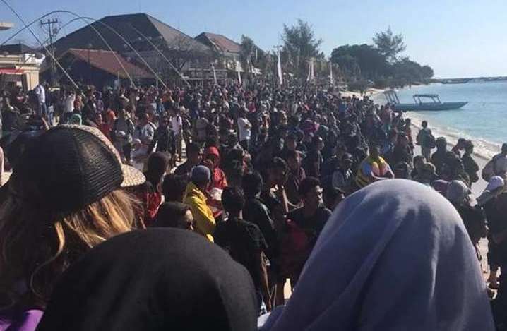 People on the beach in Lombock, Indonesia, trying to escape the island. Picture: Vicky Marchant