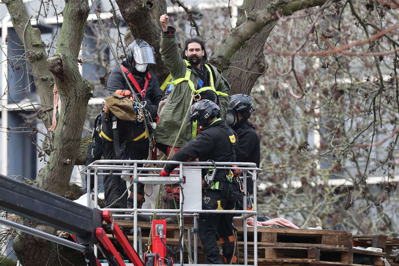 An HS2 Rebellion protester raises his fist after being removed from a tree at the encampment in Euston Square Gardens (Jonathan Brady/PA)