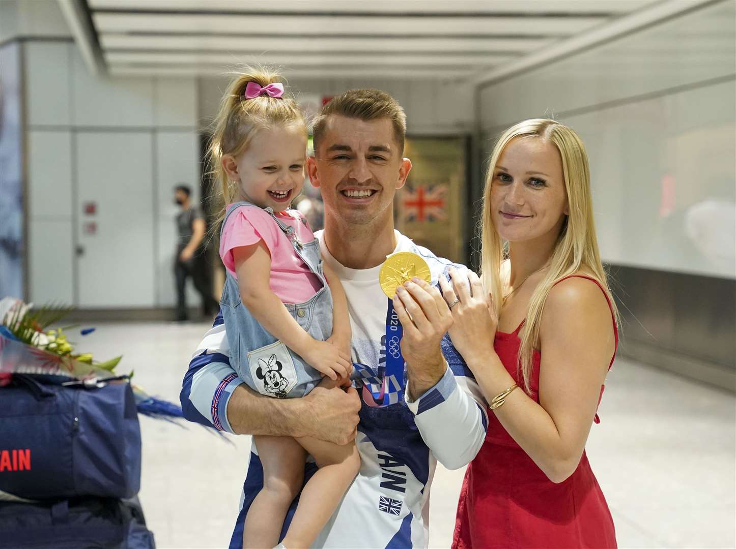 Olympic gymnast Max Whitlock with his wife Leah and daughter Willow at Heathrow Airport after the Tokyo Games (Steve Parsons/PA)