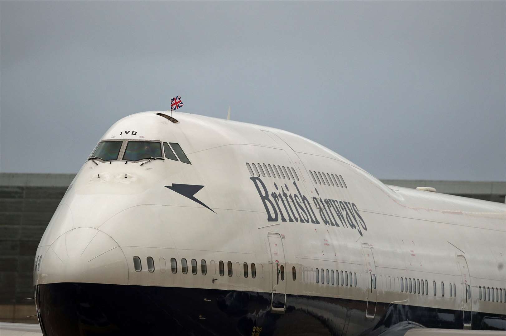 A Union flag is waved from the cockpit window of one of the last two British Airways Boeing 747-400 aircraft, designated G-CIVB, as it prepares for a final flight from Heathrow Airport, London (Steve Parsons/PA)