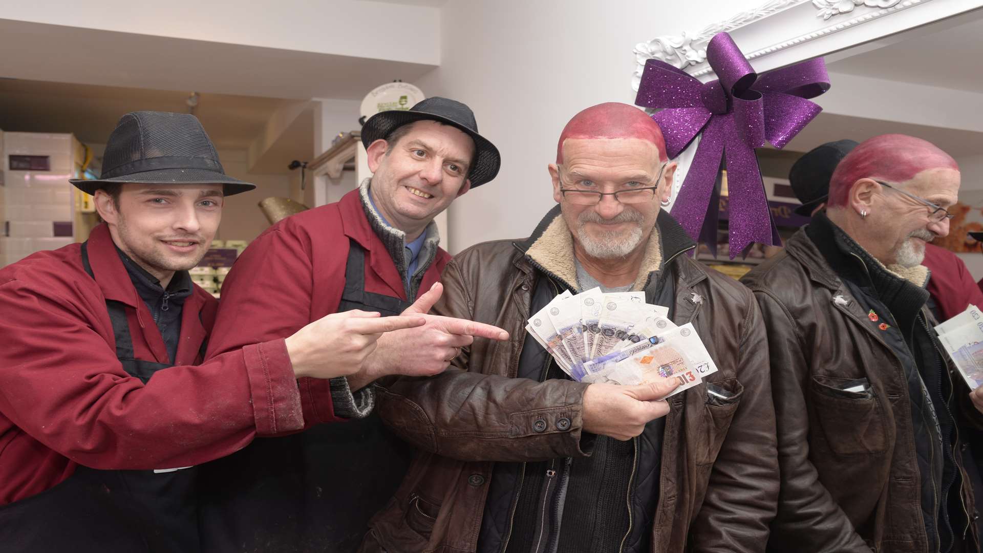 Ricky Wheatley and Darren Longhurst present Patrick Kennedy-Sanigar with the cash after he had his head died purple at the Butcher of Brogdale in Whitstable.