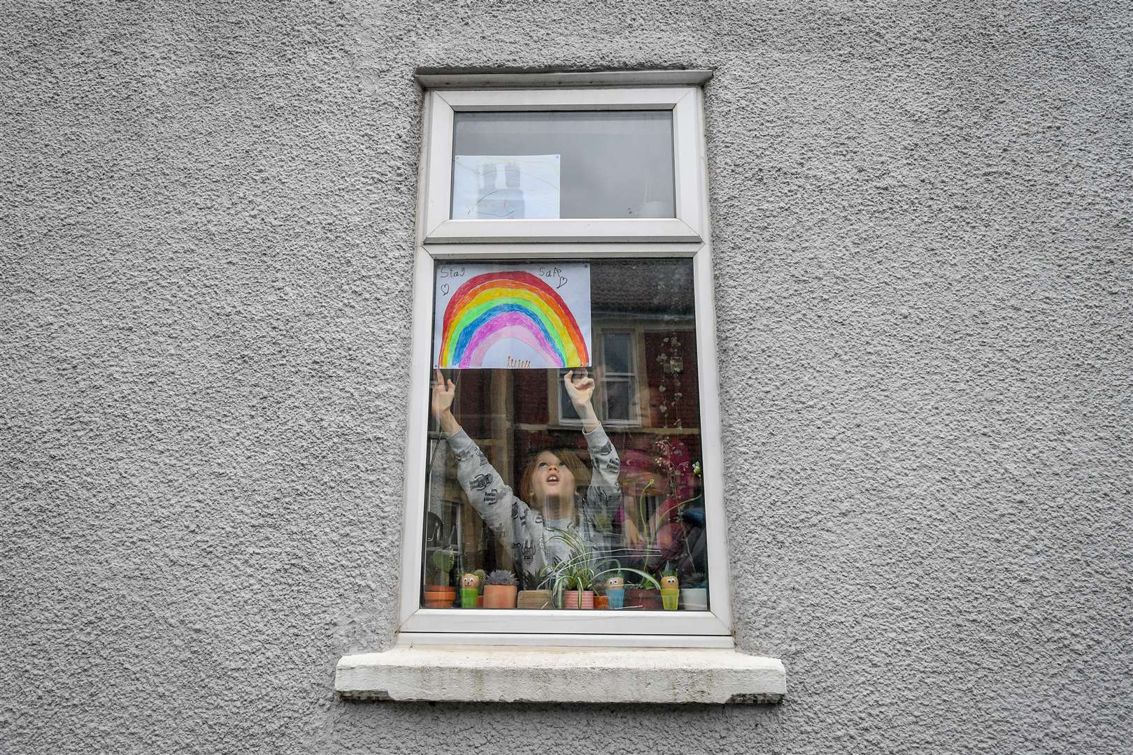 Jack Tucker, seven, places a rainbow in the window of his house in Bedminster (Ben Birchall/PA)