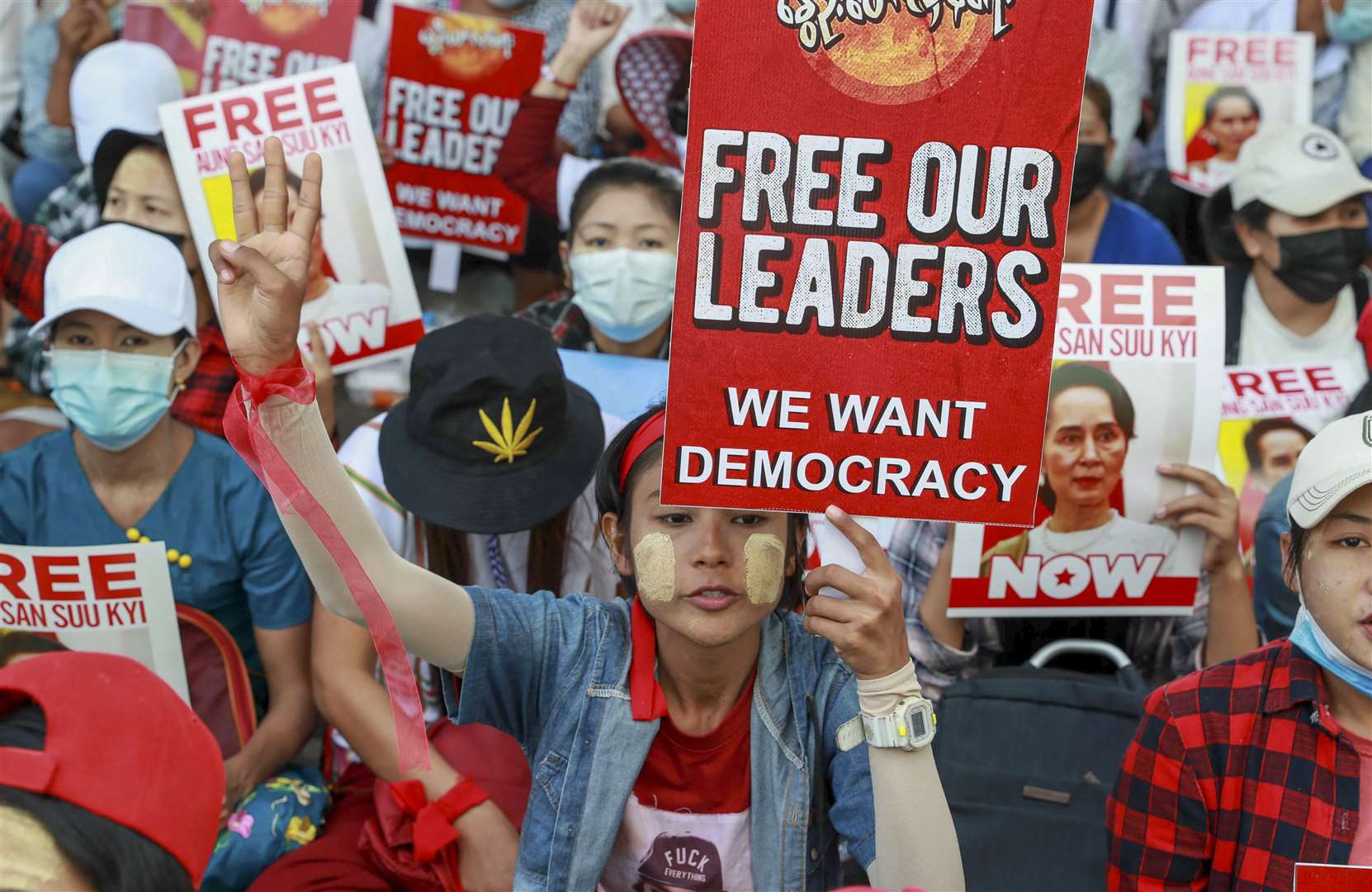 Anti-coup protesters display images of deposed Myanmar leader Aung San Suu Kyi in Yangon (AP)