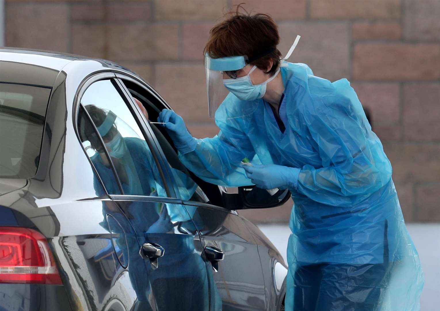 A nurse takes a sample at a Covid-19 testing centre (Andrew Milligan/PA)