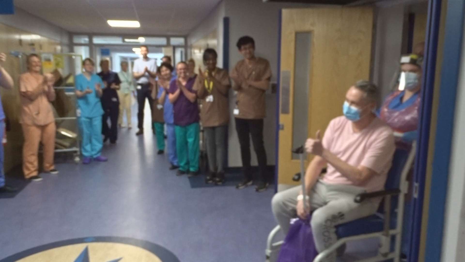 Charge nurse David Courtney-Williams gives colleagues the thumbs up as he is clapped out of Morriston Hospital (Swansea Bay UHB)