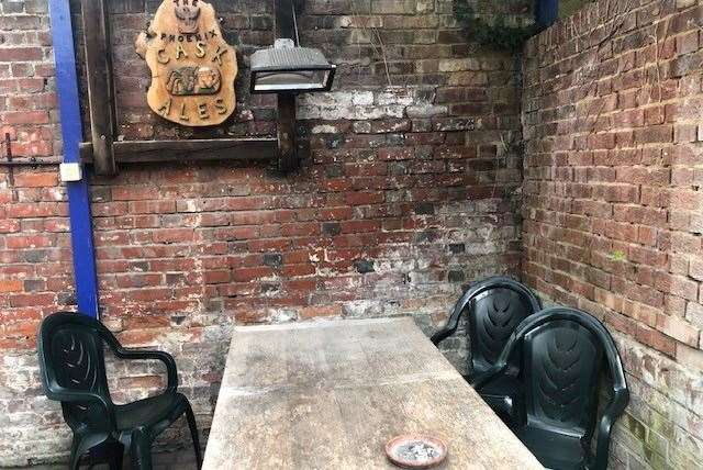 There is a small, walled smoking area at the back, protected from the rain by a plastic roof