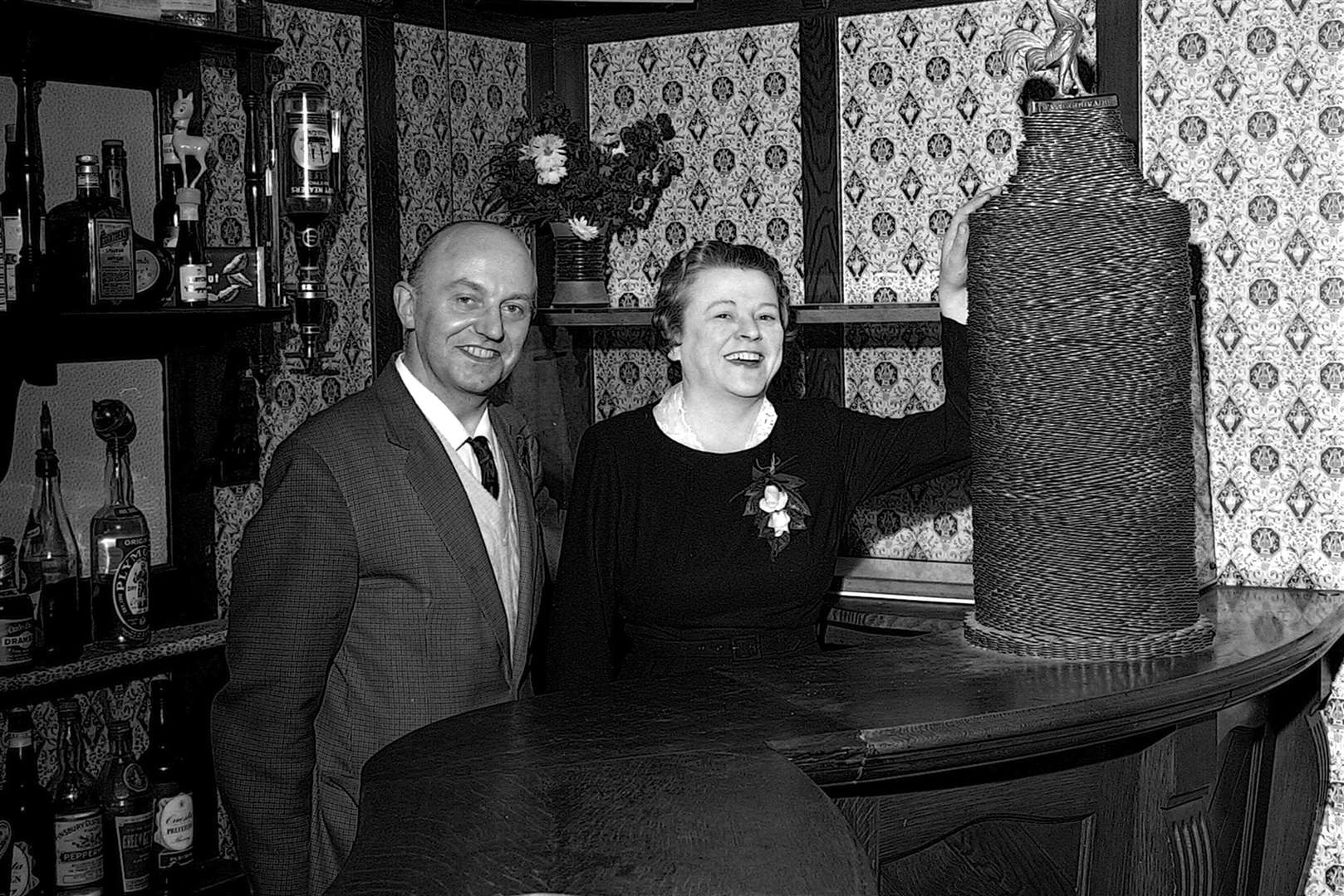 The unidentified licensees of The Swan in Tufton Street standing proudly next to their pile of pennies in 1963. Picture: Steve Salter