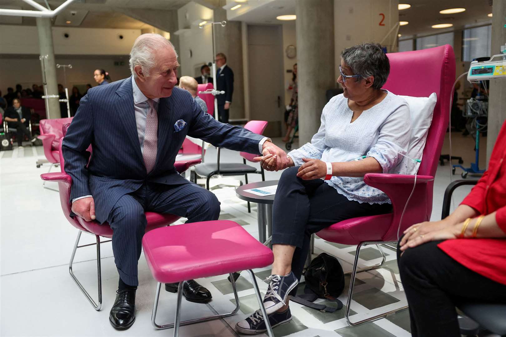 The King, who became patron of Cancer Research UK, holds patient Asha Millan’s hand at University College Hospital in April (Suzanne Plunkett/PA)