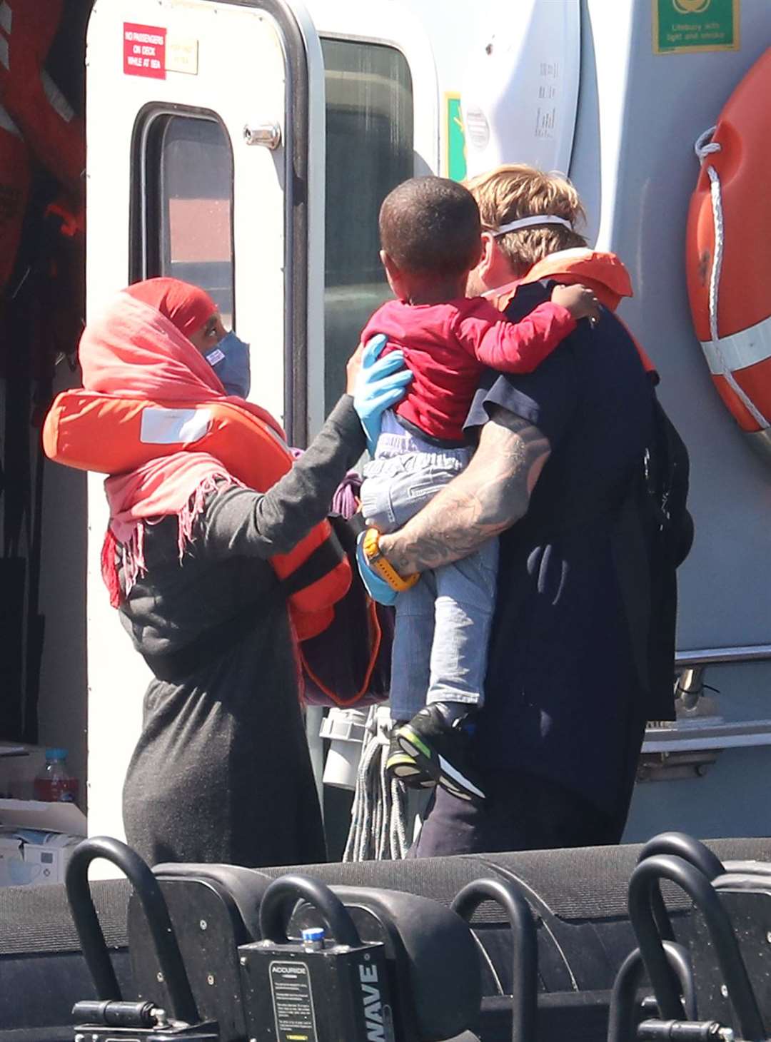 A Border Force officer helps a young boy comforted by his mother (Gareth Fuller/PA)