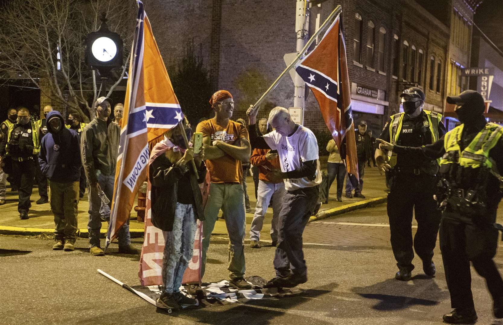 Marchers holding Confederate flags stomp on a Black Lives Matter flag in Graham, North Carolina (Khadejeh Nikouyeh/Greensboro News & Record/AP)